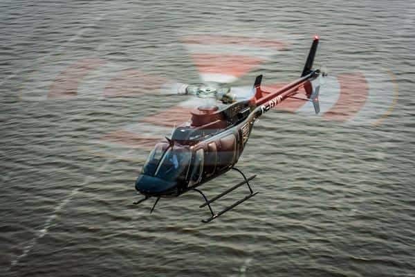 Bell 407直升机水面上空飞行
